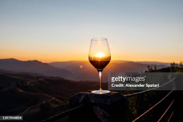 glass of red wine against sunset sunset in the mountains - winery landscape stock pictures, royalty-free photos & images