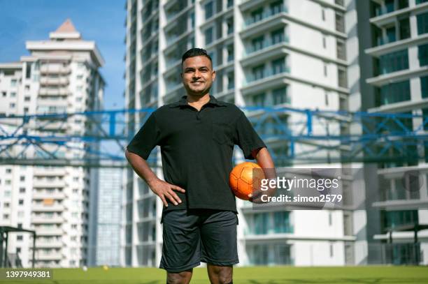 outdoor sports portrait of smiling asian male footballer on field - indian football stock pictures, royalty-free photos & images