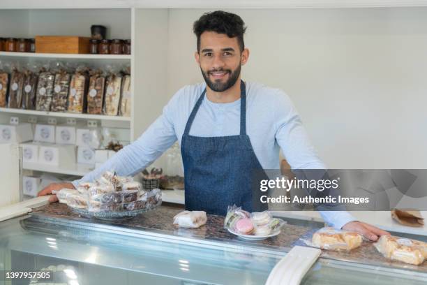 potrait di imprenditore felice al bancone che espone dolci in pasticceria - alfajores foto e immagini stock