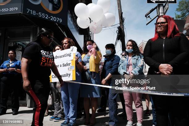 People stand beside a growing memorial during a rally for an 11-year-old girl in the South Bronx who was caught in gun crossfire on Monday and killed...
