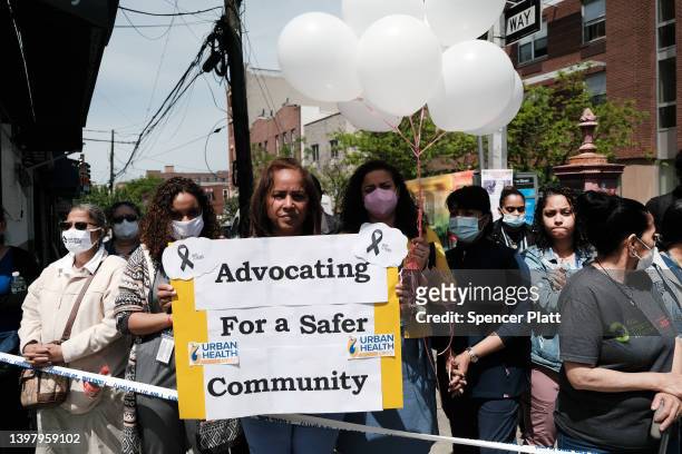 People stand beside a growing memorial during a rally for an 11-year-old girl in the South Bronx who was caught in gun crossfire on Monday and killed...