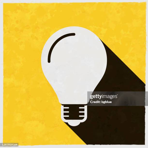 light bulb. icon with long shadow on textured yellow background - led light bulb stock illustrations