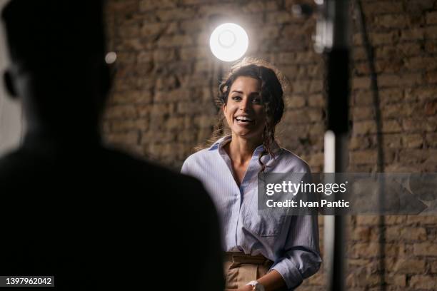 young woman giving an interview in a studio - diverse film set stock pictures, royalty-free photos & images