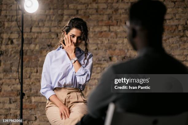 difficulty controlling emotions during an interview. woman crying during the interview - studio interview stock pictures, royalty-free photos & images