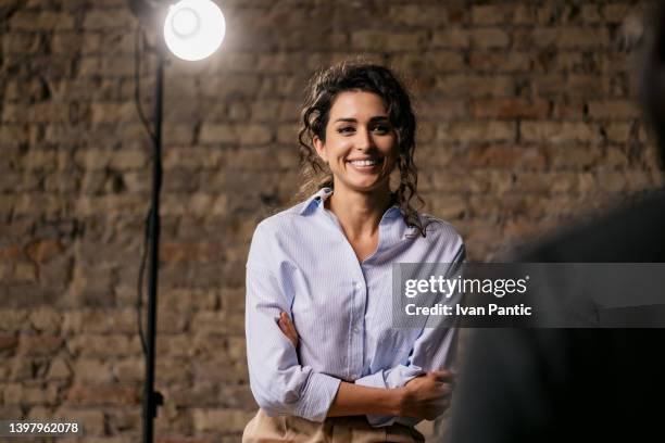 attractive woman giving an interview in a modest studio - backstage tv stock pictures, royalty-free photos & images