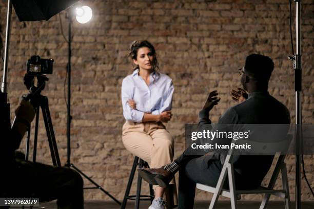 journalist interviewing a young woman in a studio - press & vip stock pictures, royalty-free photos & images