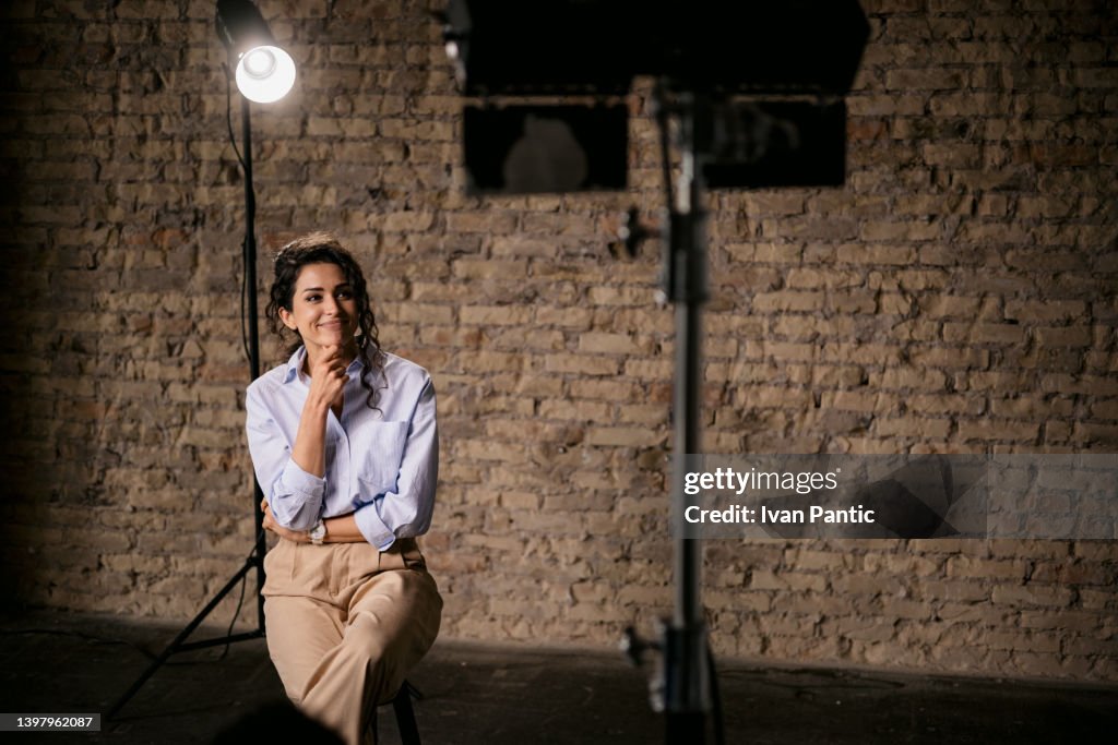 Young woman giving an interview in a studio