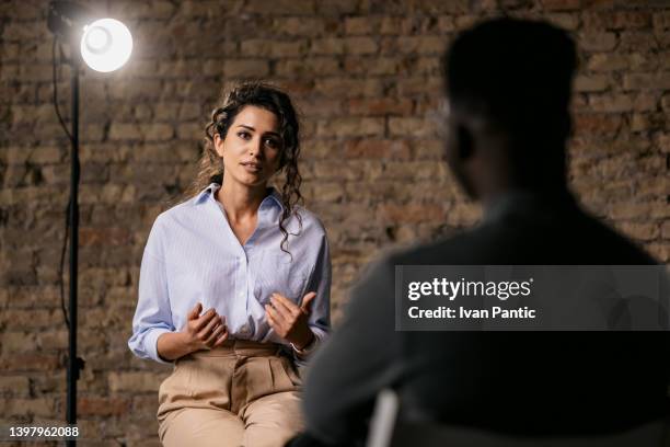 joven dando una entrevista en un estudio - entrevista con medio de comunicación fotografías e imágenes de stock