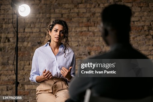 Young woman giving an interview in a studio Young woman giving an interview in a studio