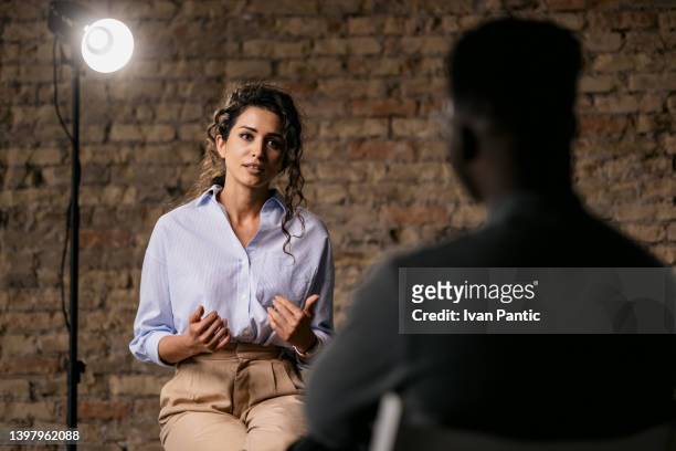 young woman giving an interview in a studio - television set imagens e fotografias de stock
