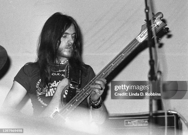Partially obscured by an audience member, Hawkwind bassist Lemmy Kilmister, performs in New York, April 1974.