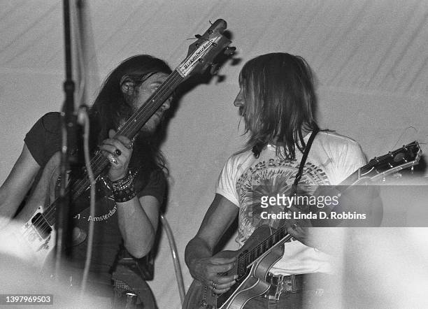 During a Hawkwind performance in New York, bassist Lemmy Kilmister has a word with guitarist Dave Brock, April 1974.