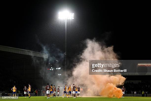 Flare is thrown onto the pitch which brings a halt to play during the Sky Bet League Two Play-off Semi Final 2nd Leg match between Northampton Town...