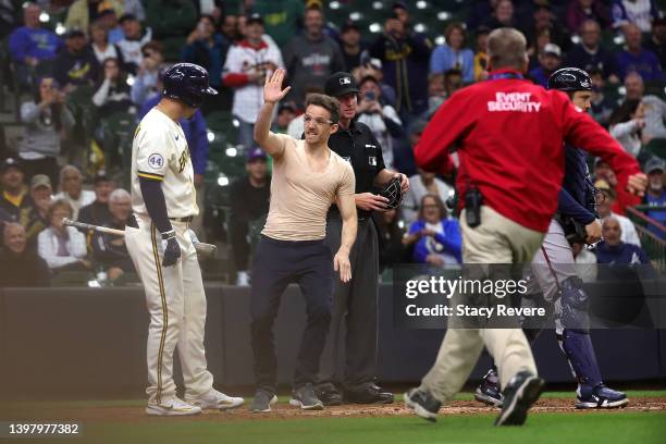 Jace Peterson of the Milwaukee Brewers watches as a fan waves after running onto the field during a game against the Atlanta Braves at American...