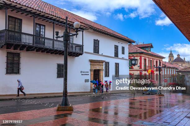 bogotá kolumbien - blick über die calle 11 in la candelaria in richtung des eingangs zur casa de moneda. spanische kolonialarchitektur und ein wenig regen. - la candelaria bogota stock-fotos und bilder