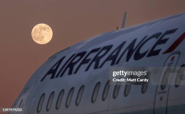 The moon rises behind retired Air France commercial passenger aircraft that have been parked up at Kemble Airfield, on January 16, 2022 in...