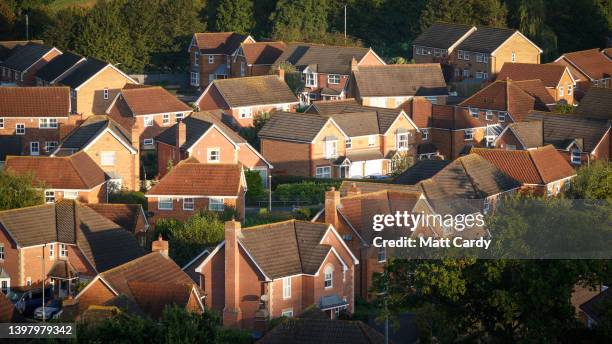 The sun shines on roofs of homes in a suburbian housing estate, on May 15, 2022 in Glastonbury, England. The UK is currently facing a cost of living...