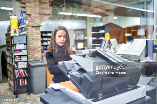 woman using a photocopier machine while working at the office. business and office tool equipment concept. - ausdrucken stock-fotos und bilder