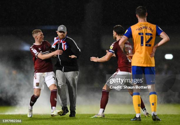 Pitch invader is stopped by Fraser Horsfall of Northampton Town during the Sky Bet League Two Play-off Semi Final 2nd Leg match between Northampton...