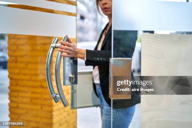 woman holding a sign while enter on a graphic printing shop. shop and business concept. - abrir a porta sair imagens e fotografias de stock