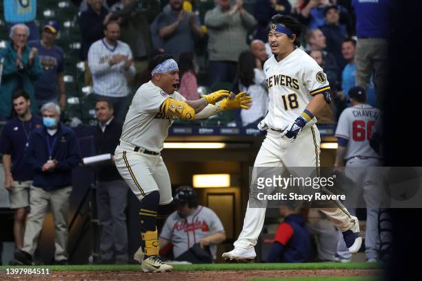 Keston Hiura of the Milwaukee Brewers is congratulated by Kolten Wong after hitting a walk off two run home run during the eleventh inning against...