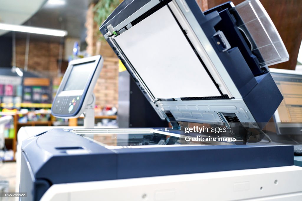 View of a modern photocopier printer machine in a workplace office. Business, office supplies and technology concept.