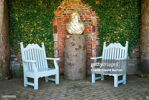 garden seats and bust on tree trunk plinth, houghton hall, norfolk, england - houghton hall stockfoto's en -beelden