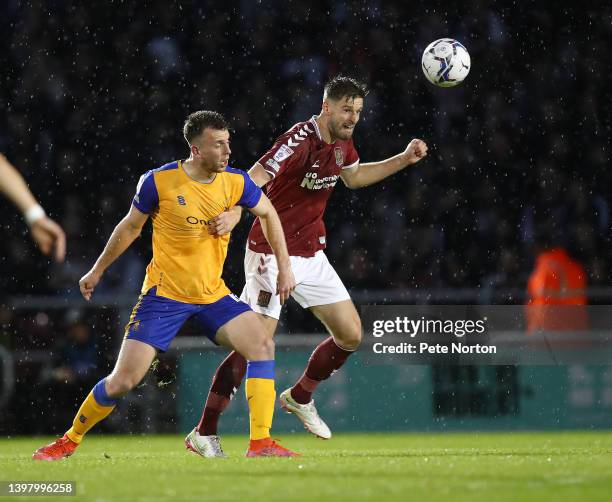 Jon Guthrie of Northampton Town heads the ball away from Rhys Oates of Mansfield Town during the Sky Bet League Two Play-off Semi Final 2nd Leg match...