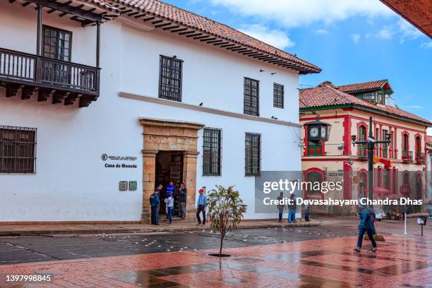 bogotá kolumbien - blick über die calle 11 in la candelaria in richtung des eingangs zur casa de moneda. spanische kolonialarchitektur und ein wenig regen. - la candelaria bogota stock-fotos und bilder