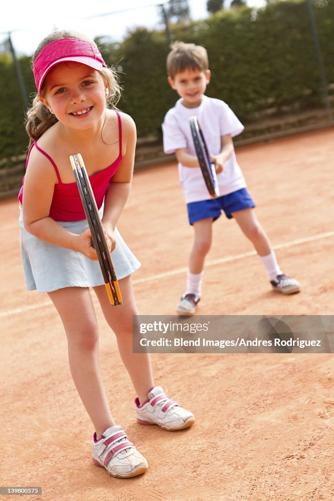 Hispanic children playing double's tennis