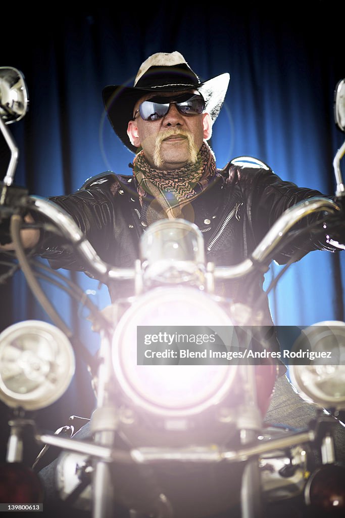 Hispanic biker sitting on motorcycle