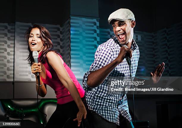 friends singing karaoke in nightclub - duet stock pictures, royalty-free photos & images