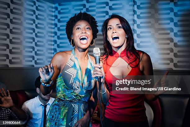 friends singing karaoke in nightclub - duet stock pictures, royalty-free photos & images