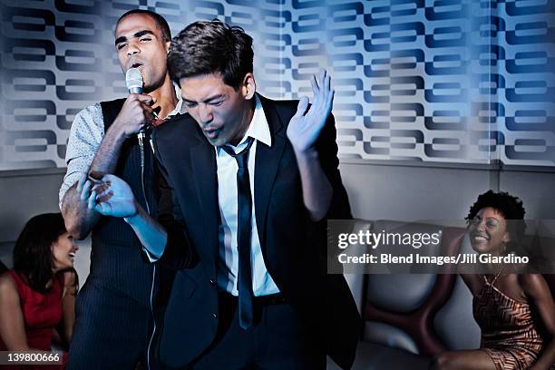 friends singing karaoke in nightclub - asian singer stock pictures, royalty-free photos & images