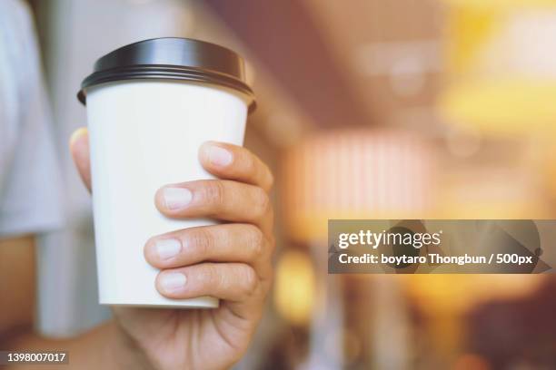 young man hand holding paper cup - mug mockup stock pictures, royalty-free photos & images