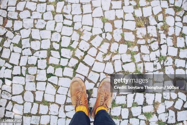 low section of man standing on cobblestone - man standing full body isolated stock pictures, royalty-free photos & images