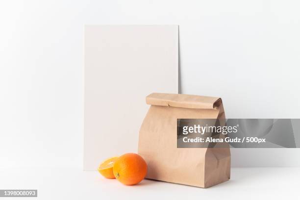 oranges with a craft paper and recyclable bag against white background - lunch bag white background stock pictures, royalty-free photos & images
