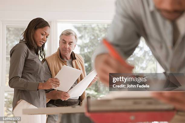 man and woman looking at blueprints together - building contractor bildbanksfoton och bilder