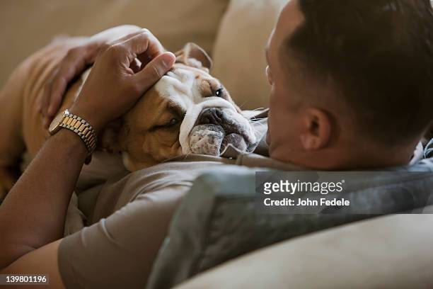 black man petting english bulldog - man and pet stock pictures, royalty-free photos & images