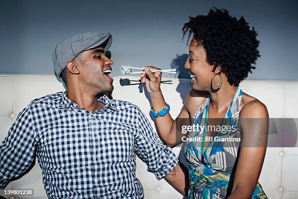 woman feeding boyfriend sushi with chopsticks - feeding bildbanksfoton och bilder