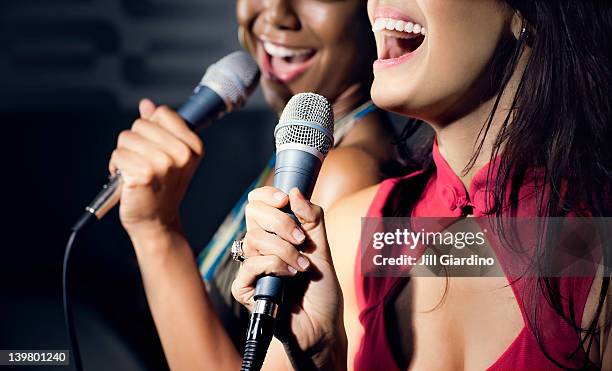 freunde singen karaoke im nightclub - microphone mouth stock-fotos und bilder