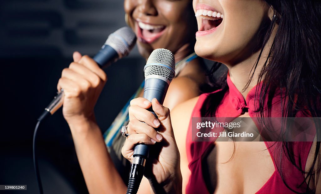 Friends singing karaoke in nightclub