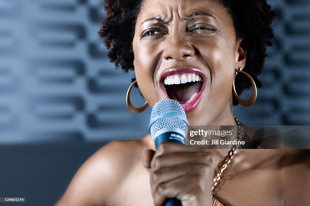 Afrikanische amerikanische Frau singen karaoke im nightclub