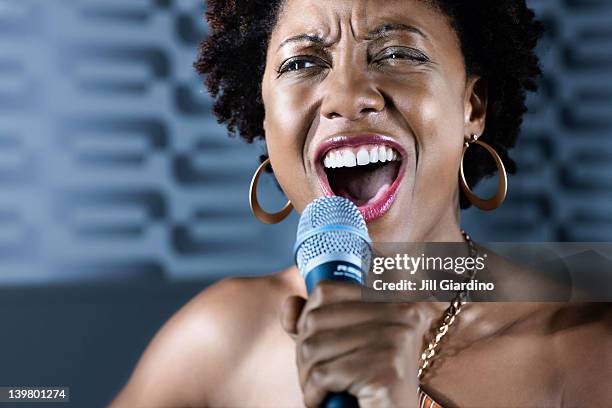 afrikanische amerikanische frau singen karaoke im nightclub - microphone mouth stock-fotos und bilder