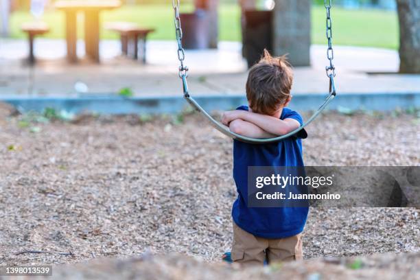 caucasian little boy crying covering his face at the schoolyard playground - autismus stock pictures, royalty-free photos & images