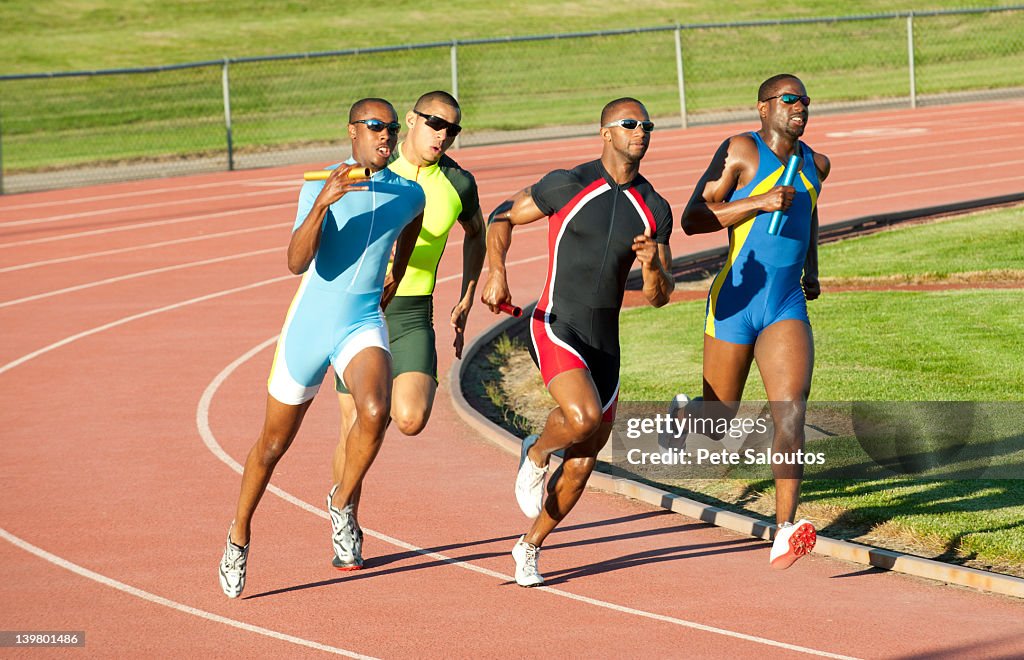 Relay racers running on track in race