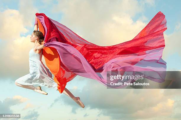 caucasian woman floating through air with scarves - color day productions stockfoto's en -beelden