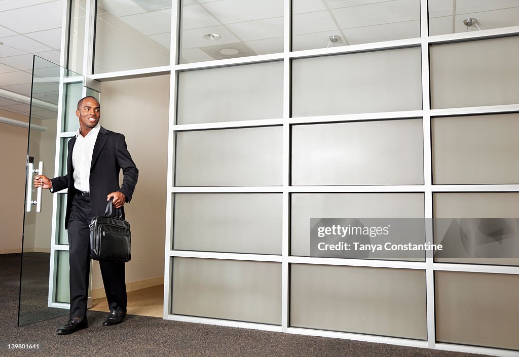 Mixed race businessman leaving modern office
