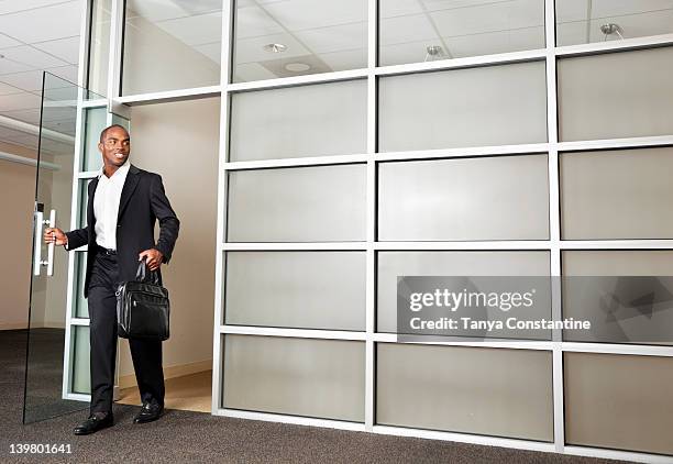 mixed race businessman leaving modern office - office doorway stock pictures, royalty-free photos & images