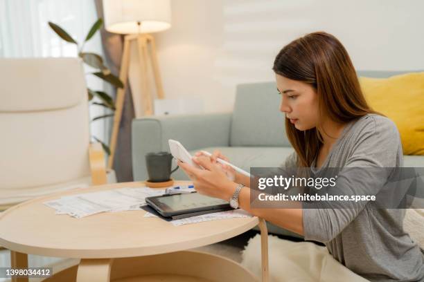 woman analyzing documents while sitting at home. - tuition stock pictures, royalty-free photos & images